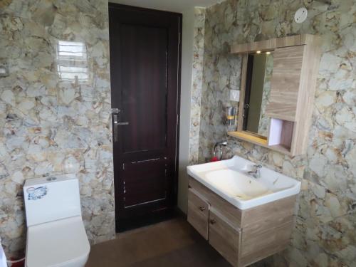 a bathroom with a sink and a toilet and a mirror at Misty Hills Retreat in Coimbatore