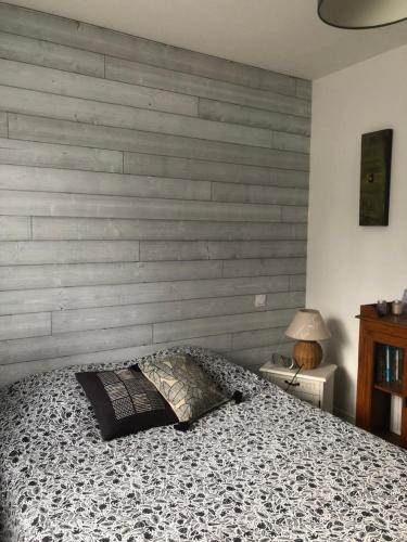um quarto com uma cama e uma parede de madeira em Jolie chambre dans quartier calme em Eysines