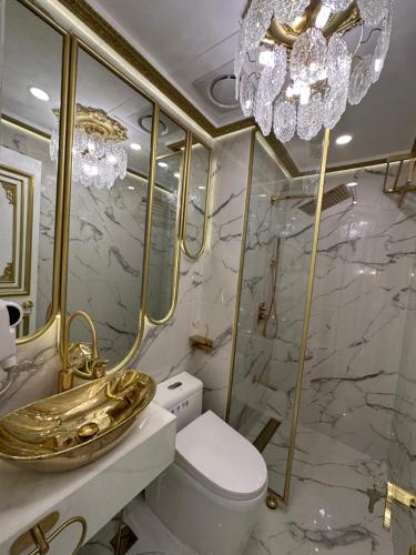 a bathroom with a gold sink and a toilet at Gramercy Residences Makati Hidden Gem in Makati