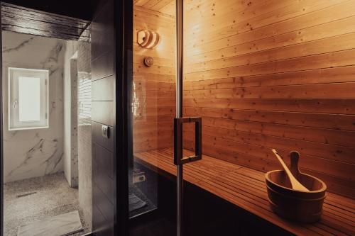 a sauna with wooden walls and a wooden bowl at La bella vita luxury apartament and travel solution in Naples