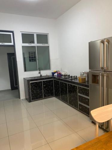a large kitchen with a stainless steel refrigerator at ZZZ HOMESTAY SKUDAI in Skudai