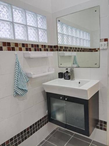 a white bathroom with a sink and a mirror at Karon Holiday Home by Bcare in Karon Beach