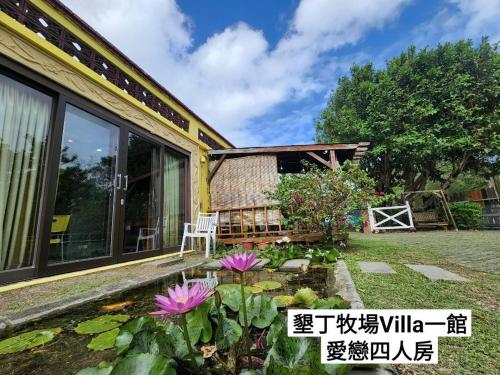 a garden in front of a house with flowers at 墾丁牧場Villa Kenting Pasture - Villa B&B in Kenting