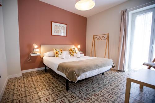 a bedroom with a bed with two lamps on it at Apartamentos Doña Concha in Seville