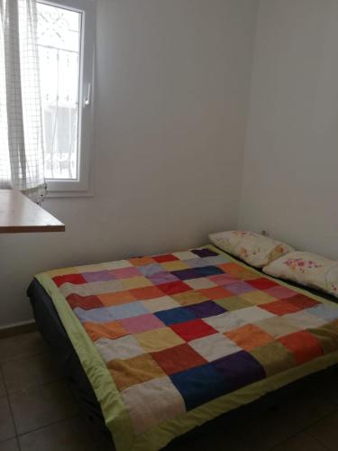 a bed in a room with a colorful quilt on it at House with garden in Bodrum in Bodrum City