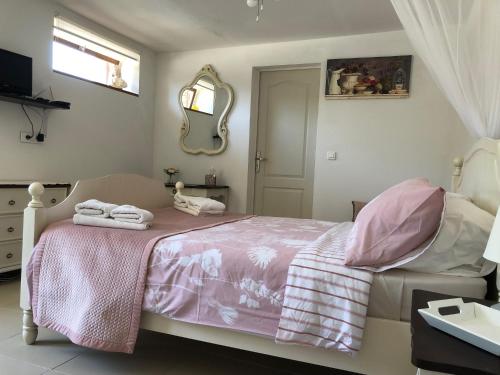 Un dormitorio con una cama rosa con toallas. en Chez Goret Gites - Gite Skippy Couples only 