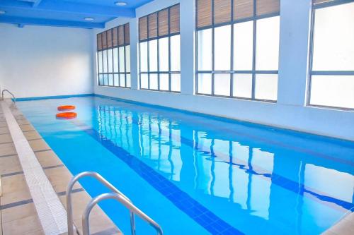 a large swimming pool with blue water at Chic 2-Bedroom Haven in Kilimani in Nairobi