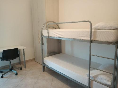ロゼート・デッリ・アブルッツィにあるDonizetti Apartment 8の二段ベッド2台、デスク、椅子が備わる客室です。