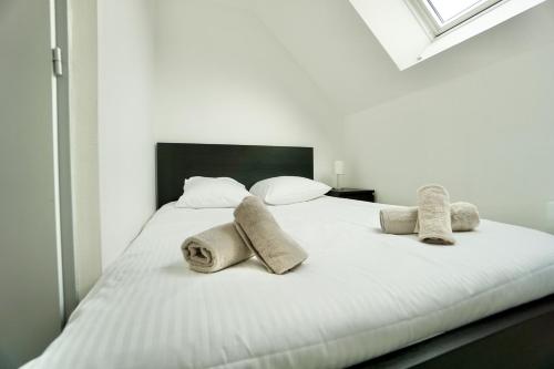 a white bed with towels and pillows on it at Cabine de plage n°1 *50m de la mer* in Ploemeur