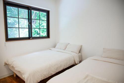 瀬底にあるフクギのお家の窓のある部屋にベッドが2つある