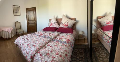 a bedroom with a large bed with red pillows at Au parfum des roses in Gunstett