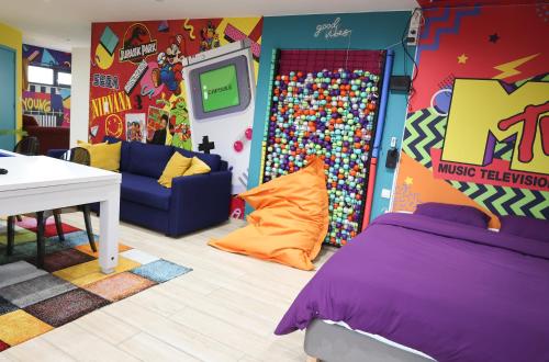 Cette chambre pour enfants comprend un lit et une télévision. dans l'établissement Capsule 90's - Jacuzzi - Sauna - Flipper - Billard - Netflix - Nintendo Switch & Jeux -, à Mons