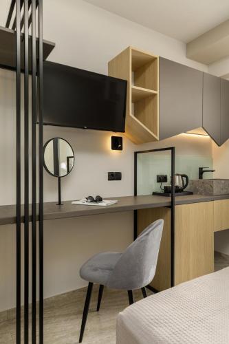 a bedroom with a desk and a chair in a room at Costa De Luxe Suites in Leptokaria
