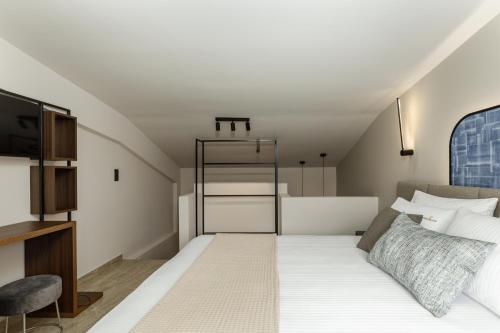 a bedroom with a large bed and a tv at Costa De Luxe Suites in Leptokaria