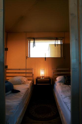 two beds in a small room with a window at Luxury Lake Lodge in Alphen
