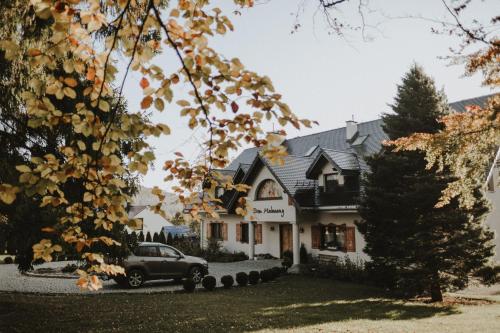 een huis met een auto ervoor geparkeerd bij Dom Malowany - Domki in Wetlina