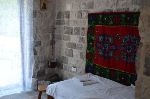a bedroom with a bed and a red blanket on the wall at Markovic Winery and Estate apartments in Cetinje