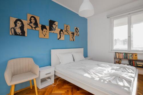 1 dormitorio con pared azul, cama y silla en Prime Location in City Center I The Blue Art Spot, en Sofía