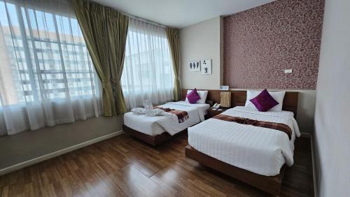 a hotel room with two beds and a window at Baiyoke Ciao Hotel in Chiang Mai