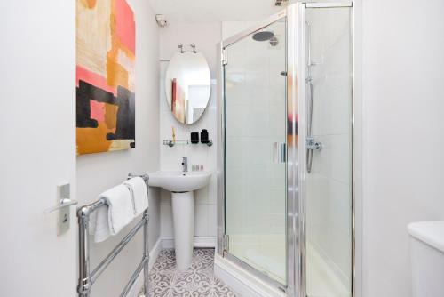 uma casa de banho com um chuveiro e um lavatório. em The Clapham Getaway - Charming 1BDR Flat em Londres