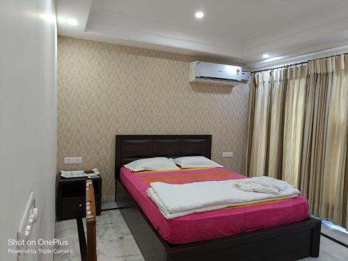 a bedroom with a bed with a red blanket at Modern Room(R1) in Heart of City in New Delhi