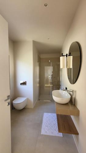 a bathroom with a sink and a toilet and a mirror at VIEW Garda Lake in Brenzone sul Garda