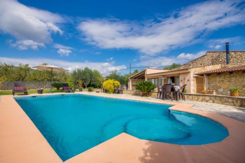 a swimming pool in front of a house at Puri in Lloseta