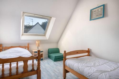 um quarto com 2 beliches e uma janela em Maison confortable et familiale pour 6 personnes em Sarzeau