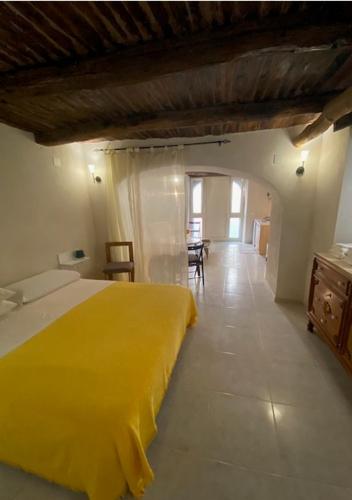 1 Schlafzimmer mit einem gelben Bett und einem Esszimmer in der Unterkunft Suite al Borgo in Montesarchio