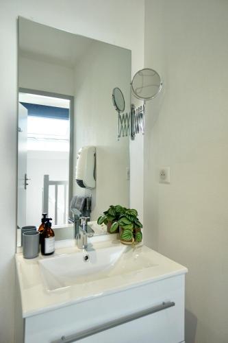 une salle de bain avec un lavabo blanc et un miroir dans l'établissement Cabine de plage n°2 *50m de la plage*, à Ploemeur