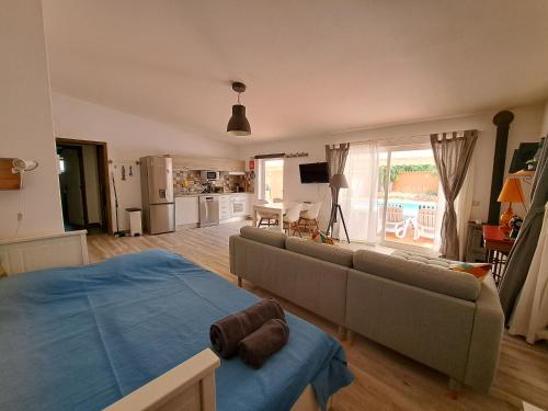 a living room with a couch and a kitchen at Villa dos Patudos in Faro