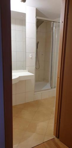 W łazience znajduje się prysznic i umywalka. w obiekcie R-PUNKT POKOJE GOŚCINNE w mieście Płock