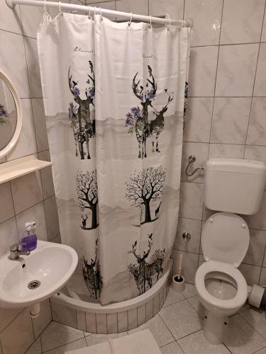 a bathroom with a shower curtain with deer on it at Apartments Menalo in Neum