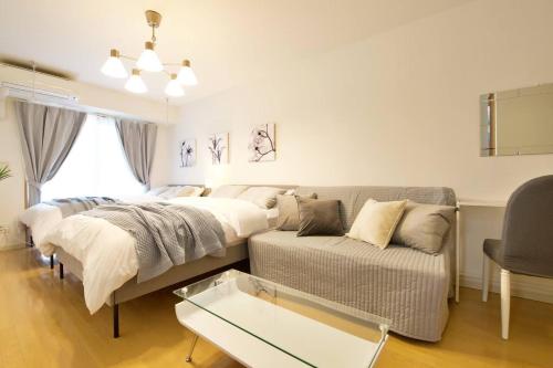 a living room with a bed and a couch at Generous Forest 201 in Tokyo