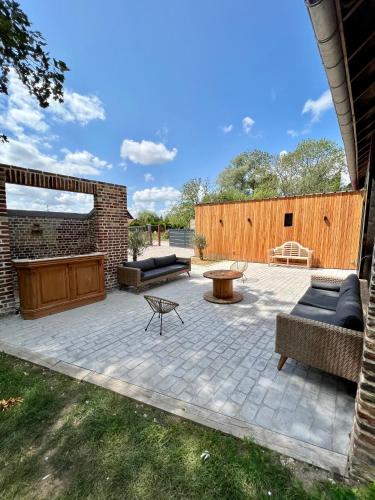 d'une terrasse avec deux canapés et une table. dans l'établissement Les volets bleus, à Saint-Venant