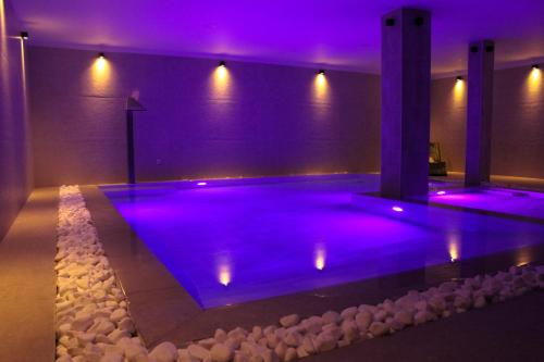 a swimming pool in a house with purple lighting at UrbanBay Hotel & Spa in Kavála