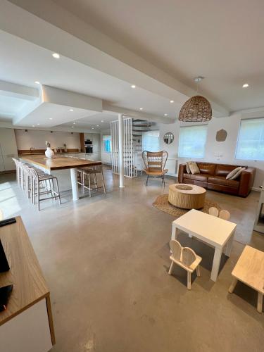 un grand salon avec un canapé et une table dans l'établissement Les volets bleus, à Saint-Venant