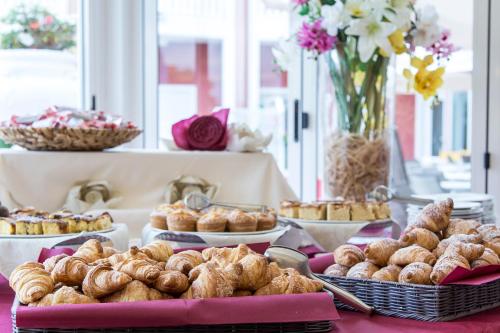 a buffet of pastries and pies on a table at Hotel Olympus in Caorle