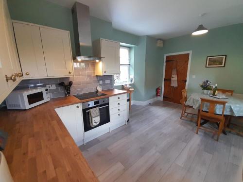 una cucina con armadietti bianchi e pavimenti in legno di Vavasour a York