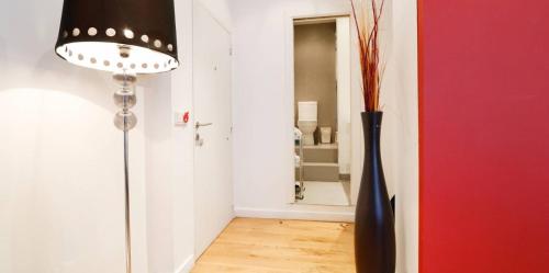 Habitación con lámpara y jarrón en el suelo en Precioso apartamento en Calle Iriarte, en Madrid