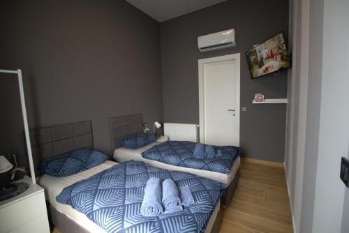 two twin beds in a bedroom with blue sheets at Rooms Matić in Velika Mlaka