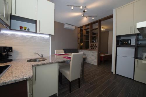 eine Küche mit weißen Schränken und einer Arbeitsplatte in der Unterkunft Apartments Branko Medjugorje in Međugorje