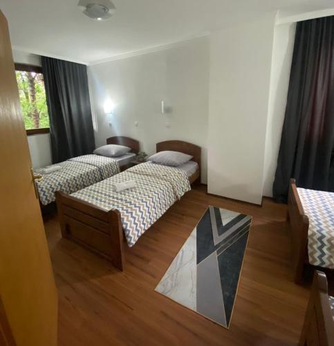 a hotel room with two beds and a rug at Hotel Lane in Kraljevo