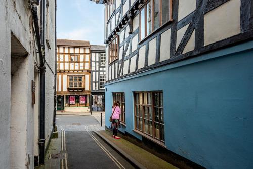 a woman standing next to a blue building at The Town House Ludlow in Ludlow