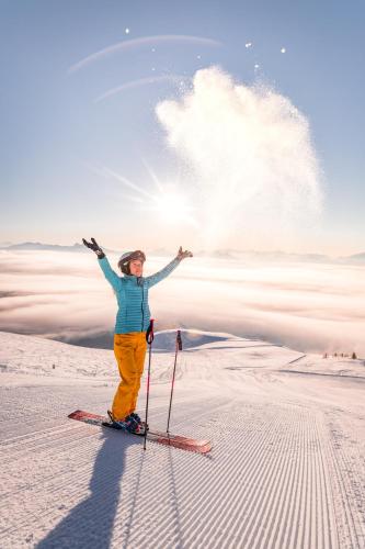 a woman is standing on skis in the snow at Das Moerisch in Seeboden