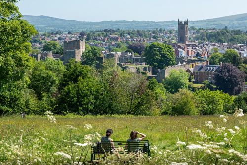 two people sitting on a bench looking at a city at The Town House Ludlow in Ludlow