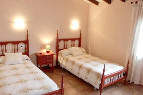 テウラーダにあるFinca Vicente - charming, Finca style holiday villa in Teuladaのベッドルーム1室(ベッド2台、ランプ付きテーブル付)