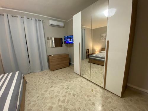 1 dormitorio con espejo, 1 cama y TV en Nonna Maria Rosa en Senise