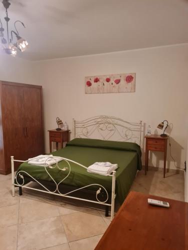 a bedroom with a green bed and a table at B&B Il Principe in San Pietro in Lama