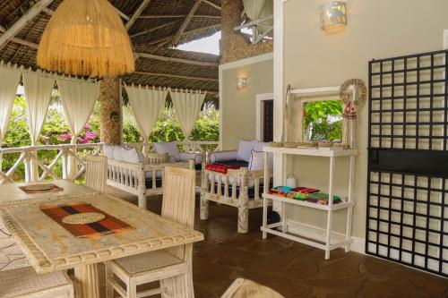 a room with a table and chairs and a mirror at Nyumba ya Afrika in Watamu